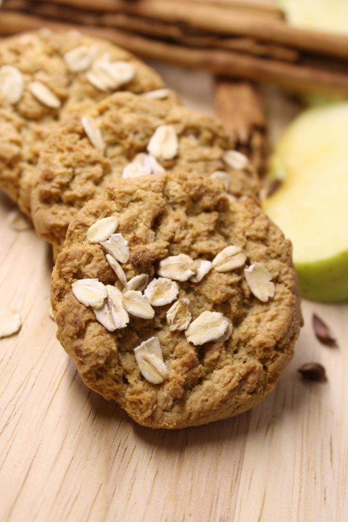 Close-up of oatmeal cookies topped with oats on a wooden background, perfect for dessert lovers.